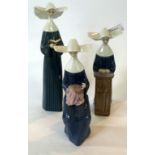 A collection of three Lladro nuns, one reading a prayer book, one praying etc (3).