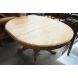 An Oval pine extending pedestal kitchen table on 4 downswept supports.