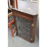 A Mahogany hanging corner cupboard with an astragal glazed door,