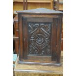 A Victorian carved oak hanging corner cupboard of small proportions,