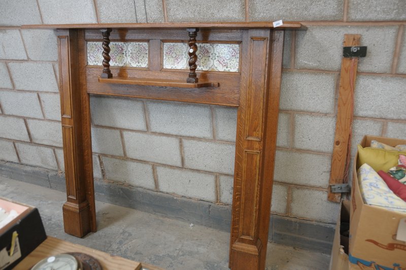 An Early 20th century oak fire surround with a tiled back above a secondary shelf with outset