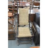 An American stained beech wood and upholstered rocking chair.