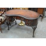 A mahogany and leather inset kidney shape writing desk
With a gadrooned border above a cockbeaded