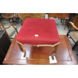 A Victorian walnut dressing stool
With a red velvet stuff over seat raised upon four curvilinear