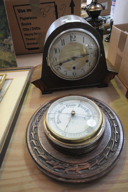 An Early 20th century oak cased mantel clock and a carved oak wheel barometer.