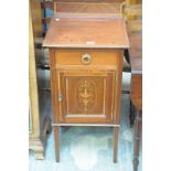 An Edwardian inlaid mahogany bedside cupboard with a single frieze drawer above a cupboard door.