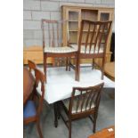 A Stag circular extending dining table with 4 conforming dining chairs.