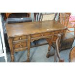 A Mid 20th century oak desk with an arrangement of 5 drawers raised on ring turned supports.