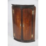 A George III oak and mahogany crossbanded hanging corner wall cupboard
With a pair of cupboard