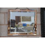 An Art deco bevelled rectangular wall mirror with an amber coloured mirrored frame.