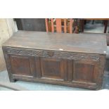 An 18th century and later oak 3 panel blanket chest with a grape and vine carved frieze.