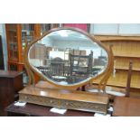 An Edwardian mahogany toilet mirror
With a shaped oval bevelled mirror enclosed by lyre shaped