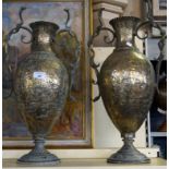 A pair of 20th Century eastern brass twin handled vases having chased decoration.