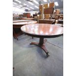 A 19th century circular mahogany centre table on a tapering octagonal column triform base and paw