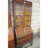 An Early 20th century oak bureau bookcase with 2 leaded glazed doors above a fall front and 2 long