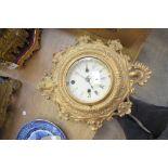 A Victorian cast gilt metal wall clock with a painted white dial.