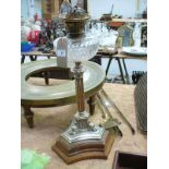 A Victorian silver plated oil lamp with a clear glass reservoir raised on a Corinthian column,