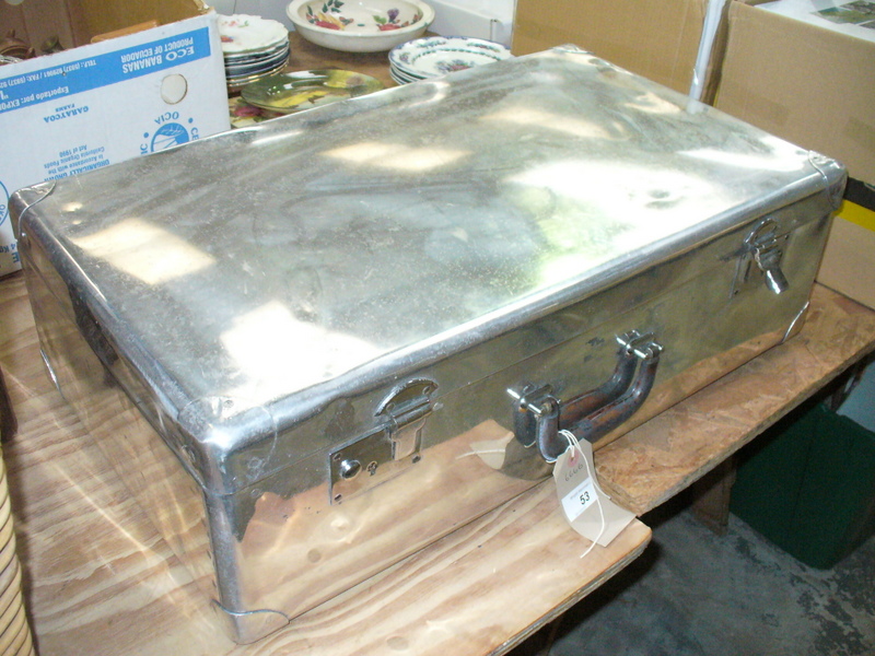 A Vintage chromed trunk with a leather handle.