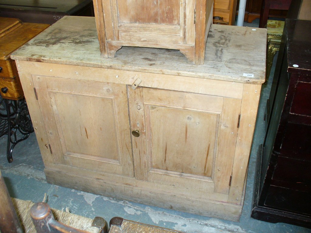 A Rustic pine 2 door kitchen cabinet on a plinth base.