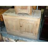 A Rustic pine 2 door kitchen cabinet on a plinth base.