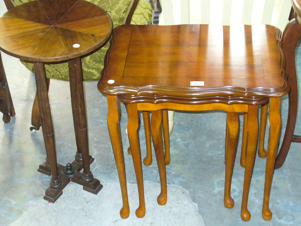 A Reproduction nest of 3 yew wood tables and a segmentally veneered pedestal table.