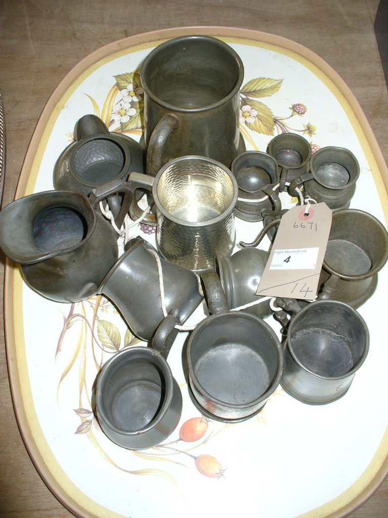14 Assorted pewter tankards and measures .