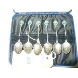 A Cased set of 6 silver coffee spoons with enamelled flower head terminals.