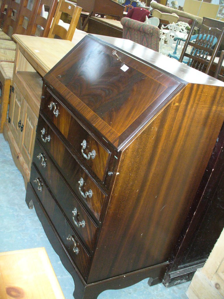 A Reproduction mahogany Georgian style bureau with a fall front above 4 long drawers.