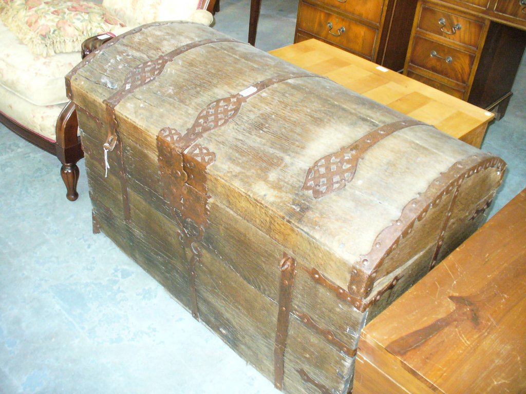 A 17th Century iron bound oak domed trunk
Flanked by twin carrying handles,