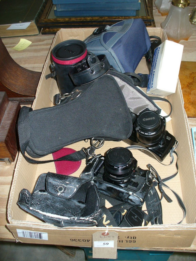 A Canon A1 camera, a Canon EOS 500 camera, a cased Sigma lens and other cameras.