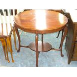 An Oval mahogany occasional table on curvillinear legs.
