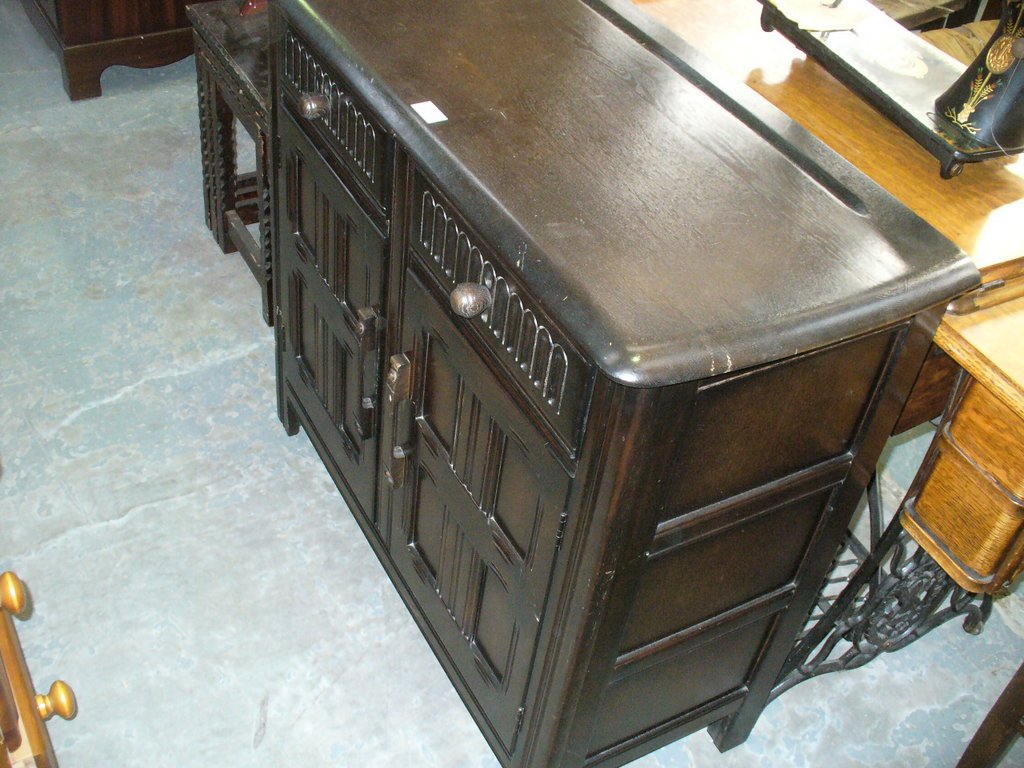 An Oak priory style sideboard with 2 drawers above 2 cupboard doors.