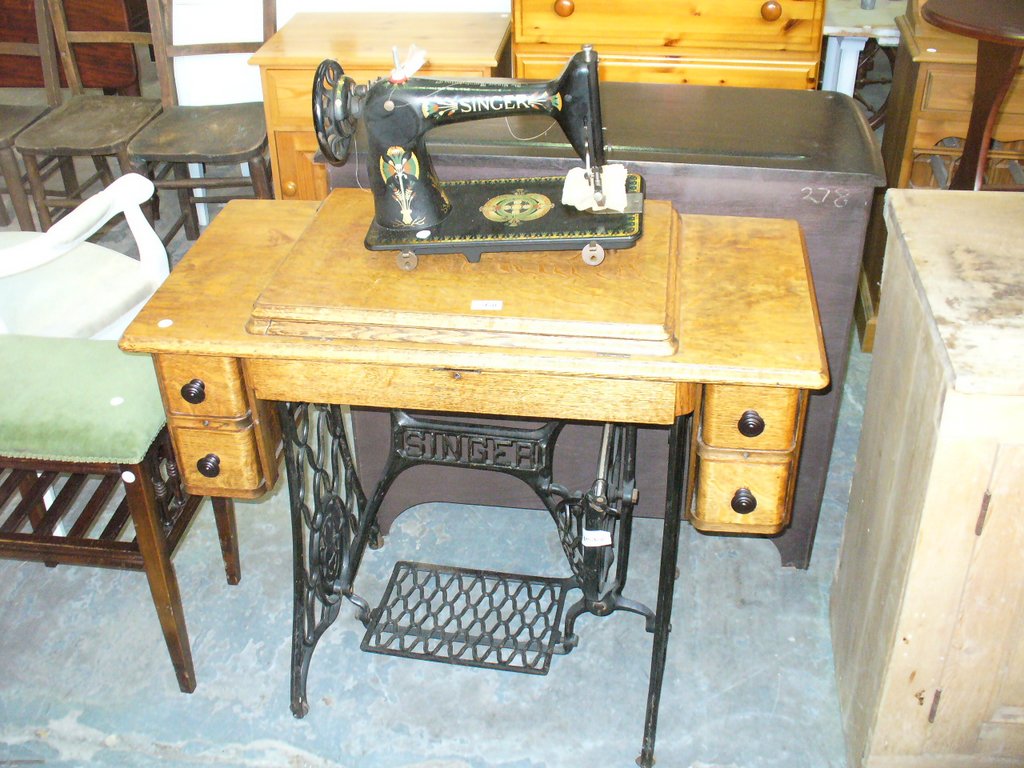 An Oak cased Singer treadle sewing machine.