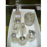 A Silver topped globular glass dressing table jar the cover embossed with scrolling leaves and