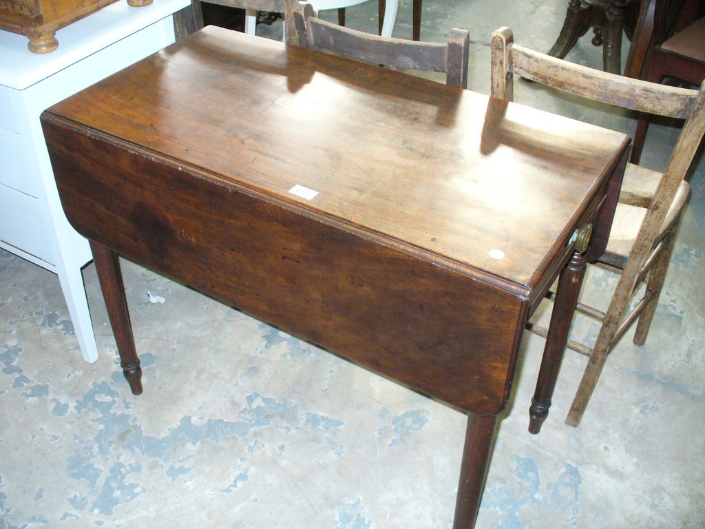 A 19th Century mahogany Pembroke table with a single frieze drawer raised on ring turned supoorts.