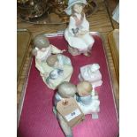 A Nao group , two children sat on a bench, a Lladro group two children with a kitten,