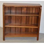 A contemporary solid wood bookcase of simple form on block supports, width 90cm.