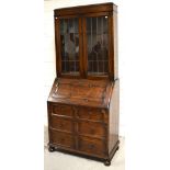 A 20th century oak bureau bookcase on bun feet, width 88cm.