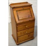 A contemporary pine bureau of small proportions, with integral green leather inset writing surface,