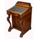 A Victorian walnut Davenport with serpentine front and blue leather inset writing surface,