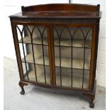 A 20th century display cabinet with a pair of astragal glazed doors enclosing fitted shelves,