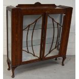 A 1930s display cabinet, with pair of astagral glazed doors and raised on cabriole legs,