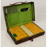 A vintage leather cased mahjong set with resin tiles, with manuals, 35.5 x 24cm. CONDITION REPORT: