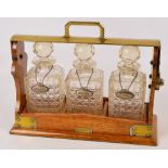 An Edwardian oak and silver plate mounted three bottle tantalus,