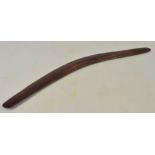 A late 19th/early 20th century Australian boomerang with adzed decoration to one side and with