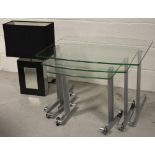 A retro nest of three rectangular glass and chromed tables,