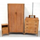 A mid 20th century light oak bedroom suite comprising two door wardrobe with fitted interior,