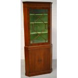 A reproduction corner display cabinet with astragal glazed single door above twin cupboard doors