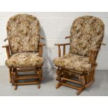 A pair of reproduction oak framed rocking chairs with floral upholstered seat pads.