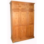 A large contemporary pine three door wardrobe with three cupboard sections to the top, width 145cm.